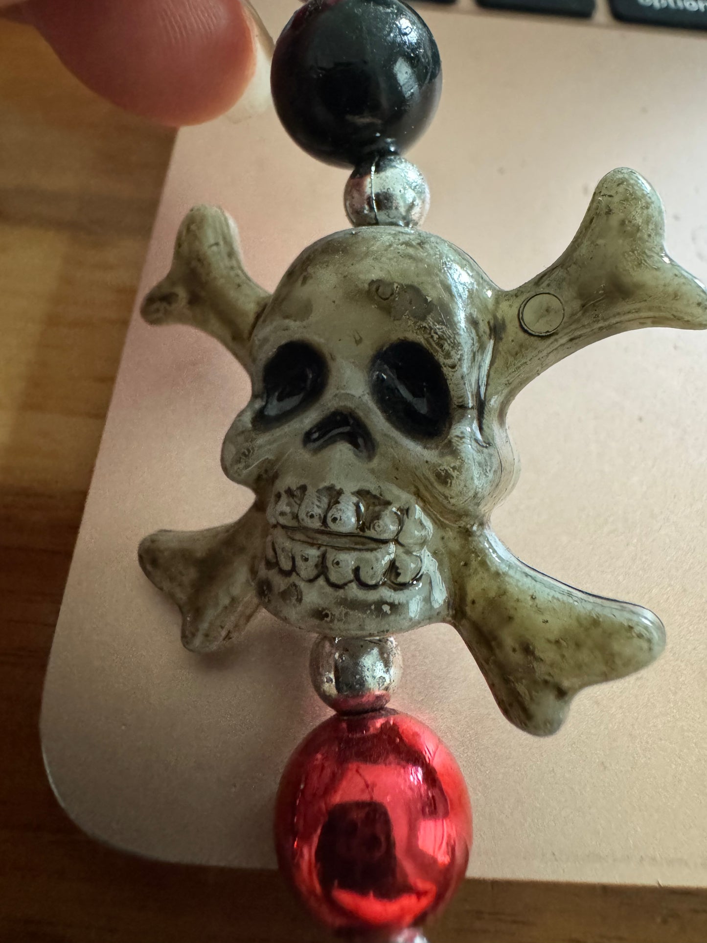 Grey skull and crossbones black and red bead